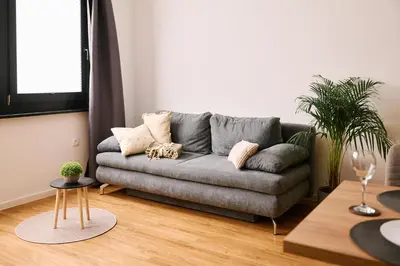 a living room with a gray couch with pillows at Mozirje Comfort Apartments in Mozirje