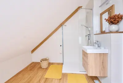 a bathroom with a sink and a shower in a attic at Mozirje Comfort Apartments in Mozirje