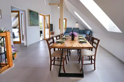 a dining room with a wooden table and chairs at House Elipsa in Bovec
