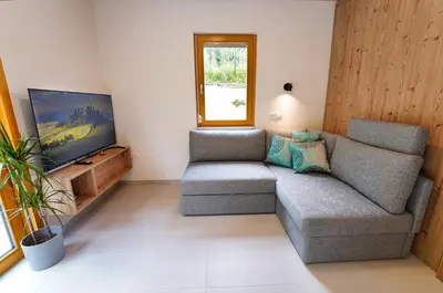 a living room with a couch and a flat screen tv at House Elipsa in Bovec