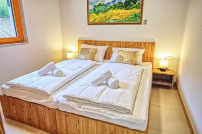 a bedroom with a large bed with white sheets and pillows at House Elipsa in Bovec