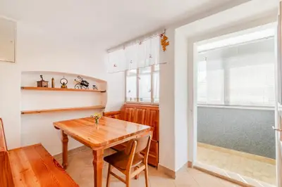 a dining room with a wooden table and a window at Holiday Homes Pr Pelaku with Outdoor Sauna in Slappe dʼIdria