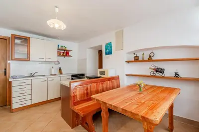 a kitchen with a wooden table and a wooden table sidx sidx sidx at Holiday Homes Pr Pelaku with Outdoor Sauna in Slappe dʼIdria