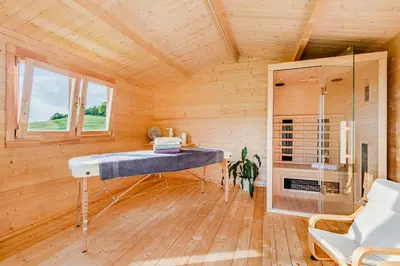 a room with a bed in a wooden room at Holiday Homes Pr Pelaku with Outdoor Sauna in Slappe dʼIdria