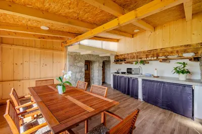 a kitchen and dining room with a wooden table and chairs at Holiday Homes Pr Pelaku with Outdoor Sauna in Slappe dʼIdria
