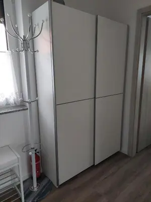 a white cabinet in a room with a window at Apartment house Petra in Cerklje na Gorenjskem