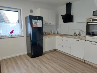 a kitchen with a black refrigerator and a window at Apartment house Petra in Cerklje na Gorenjskem