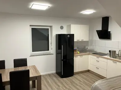 a kitchen with a black refrigerator and a table at Apartment house Petra in Cerklje na Gorenjskem
