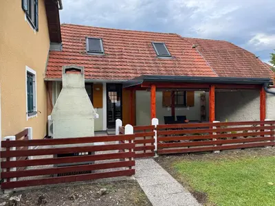 a house with a wooden fence in front of it at Hiška HOME- TERME ČATEŽ - VKLJUČENE KOPALNE KARTE in Čatež ob Savi