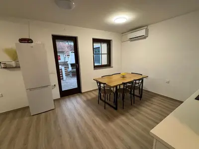 a kitchen and dining room with a table and chairs at Hiška HOME- TERME ČATEŽ - VKLJUČENE KOPALNE KARTE in Čatež ob Savi