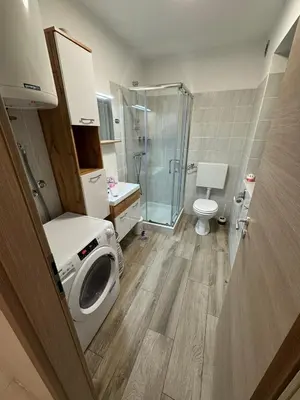 a bathroom with a shower and a washing machine at Hiška HOME- TERME ČATEŽ - VKLJUČENE KOPALNE KARTE in Čatež ob Savi