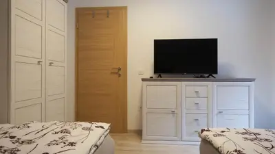 a bedroom with a tv on top of a dresser at Hiša Lunna - Apartments in a Forest Paradise in Vitanje