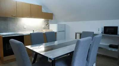 a kitchen with a dining room table and chairs at Hiša Lunna - Apartments in a Forest Paradise in Vitanje