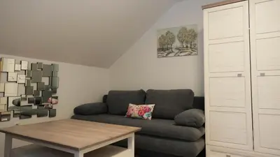 a living room with a couch and a table at Hiša Lunna - Apartments in a Forest Paradise in Vitanje