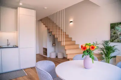 a kitchen and dining room with a vase of flowers on a table at Apartma Zeleni Biser in Bovec