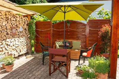 a patio with a table with a yellow umbrella at Relax apartma Peter in Ptuj
