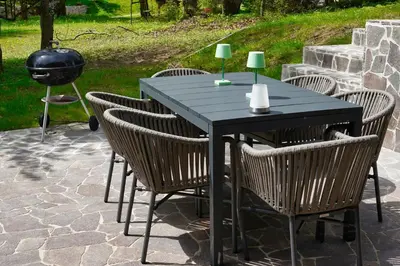a black table with chairs and a grill at Cottage of peace, Ljubljana area in Rakitna