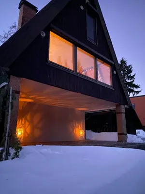 a house with its garage door open in the snow at Cottage of peace, Ljubljana area in Rakitna