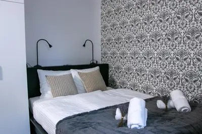 a bedroom with a bed with white towels on it at Residence Black&White in Ljubljana