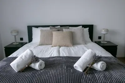 a bedroom with a bed with three towels on it at Residence Black&White in Ljubljana