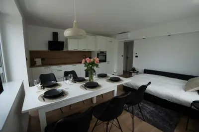 a room with a table with chairs and a bed at Residence Black&White in Ljubljana