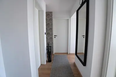 a hallway with a mirror and a rug at Residence Black&White in Ljubljana