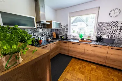 a kitchen with wooden cabinets and a clock on the wall at Arnold's Nest in Kotlje