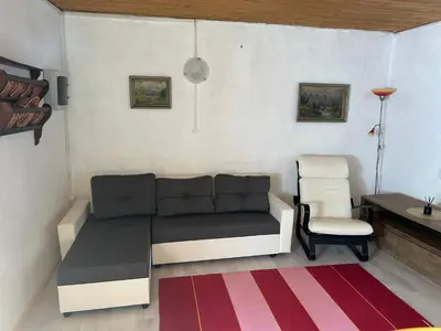 a living room with a couch and a chair at Holiday home by the emerald river in Soča