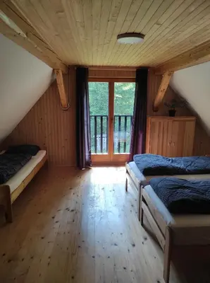 a bedroom with two beds and a large window at Holiday home by the emerald river in Soča