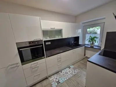 a kitchen with white cabinets and a stove top oven at Apartma Ježevi in Sežana