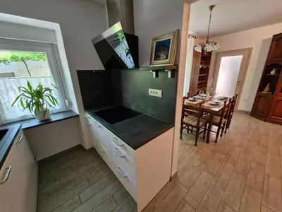 a kitchen with a counter and a dining room at Apartma Ježevi in Sežana