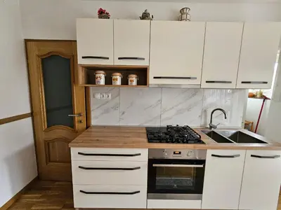 a kitchen with white cabinets and a stove top oven at Apartma Cipresa in Rogatec