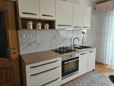 a kitchen with white cabinets and a stove top oven at Apartma Cipresa in Rogatec