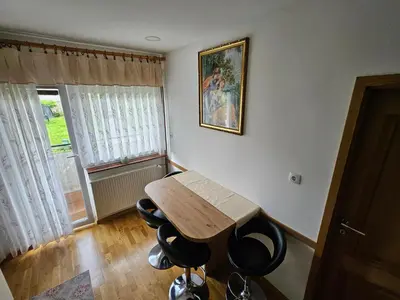 a small room with a wooden table and some chairs at Apartma Cipresa in Rogatec