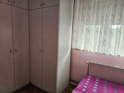 a bedroom with a pink bed and a window at Apartma Cipresa in Rogatec