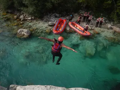 a man jumping into the water in a river at Apartma Mirko in Bovec