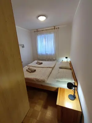 a small bedroom with a bed and a window at Apartma Mirko in Bovec