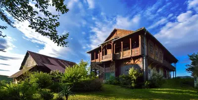 a large wooden house sitting on top of a field at Vila Zora in Dobrna