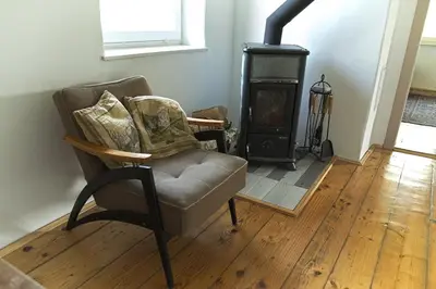 a living room with a chair and a wood stove at Vila Zora in Dobrna