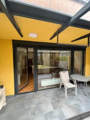 a patio with sliding glass doors and a table and chairs at Oasis Atrium Apartment with free parking in Ljubljana