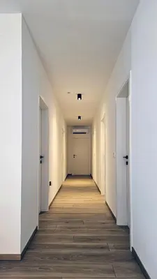 an empty hallway with white walls and wooden floors at Apartment MoiRai in Gračišče