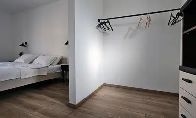 a bedroom with a bed and a white wall at Apartment MoiRai in Gračišče