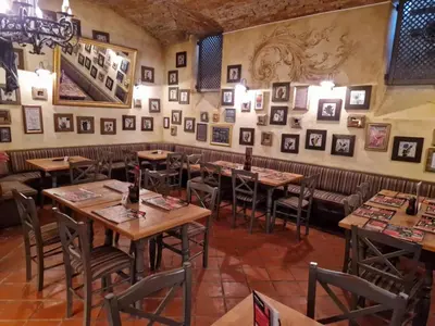 a restaurant with wooden tables and pictures on the wall at Apartma Marija - Terme Dobrna in Dobrna
