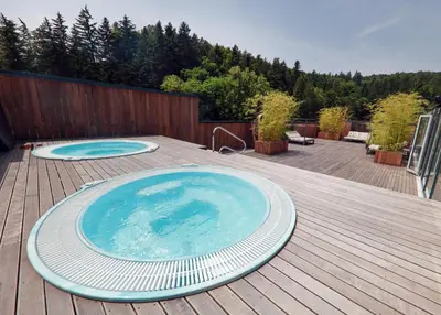 a large swimming pool on a deck with a wooden deck at Apartma Marija - Terme Dobrna in Dobrna