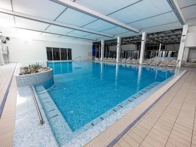 a large swimming pool with chairs in a building at Apartma Marija - Terme Dobrna in Dobrna