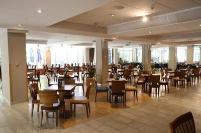 a restaurant with wooden tables and chairs and windows at Apartma Marija - Terme Dobrna in Dobrna