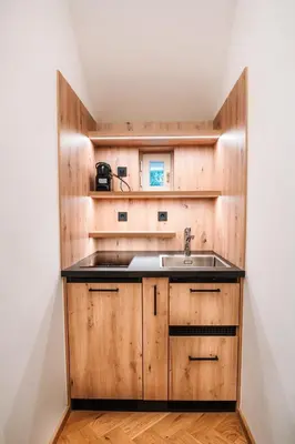 a kitchen with wooden cabinets and a sink at Apartma Marija - Terme Dobrna in Dobrna