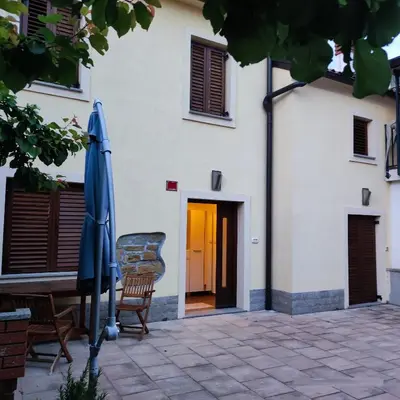 an umbrella and chairs in front of a building at Casa Rosmarin in Spodnje Škofije