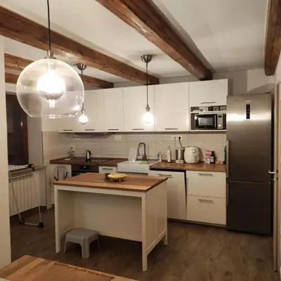 a kitchen with white cabinets and a black refrigerator at Casa Rosmarin in Spodnje Škofije