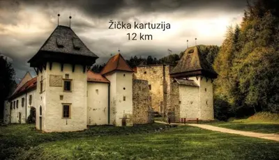 an old building in a field with a cloudy sky at Hiška Tilia in Loče pri Poljčanah